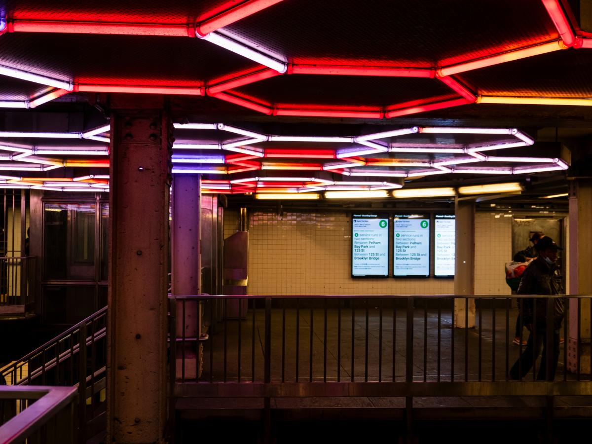 Neon lights on the ceiling of a subway station. 