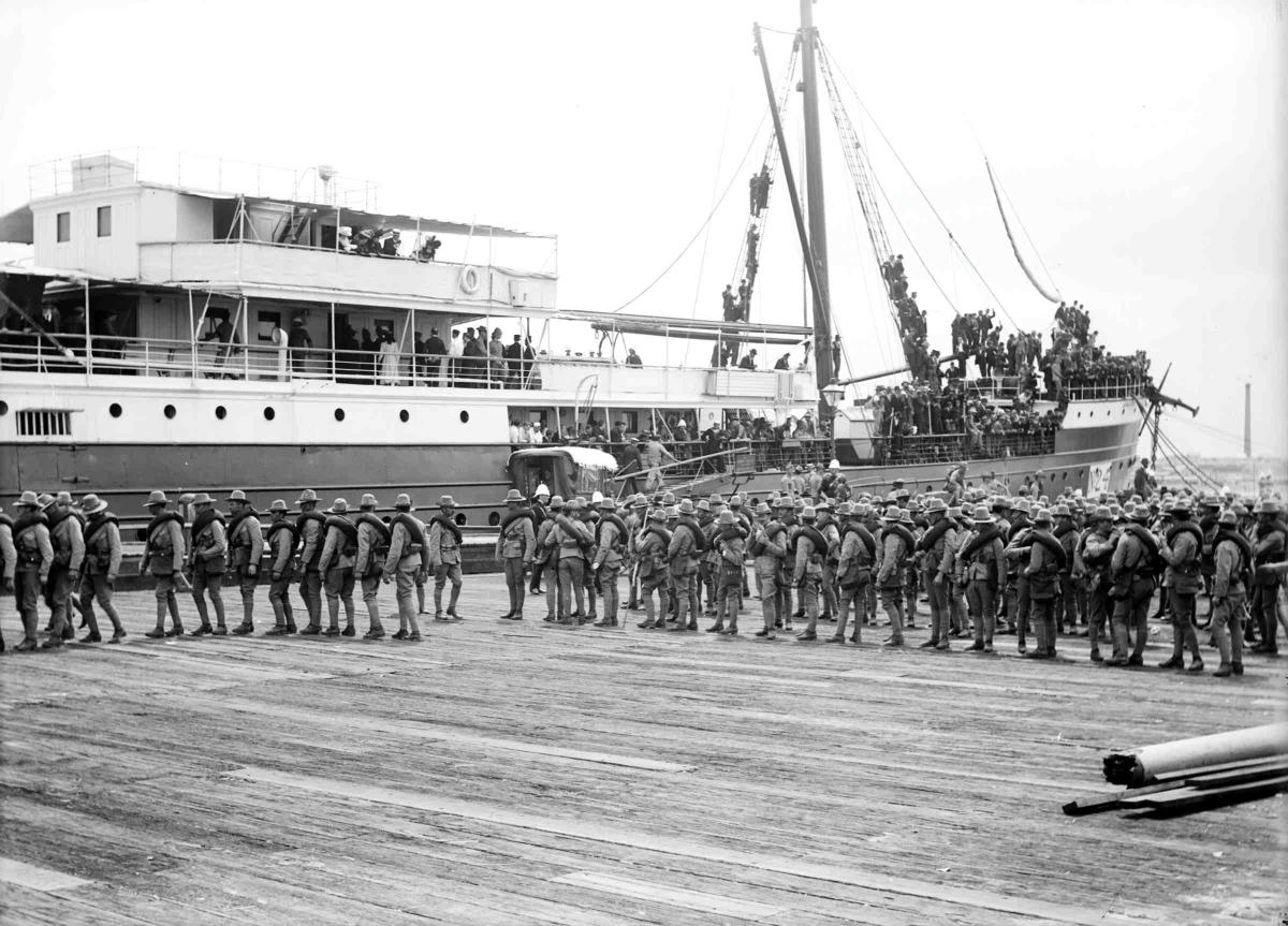 Soldiers boarding a military vessel. 